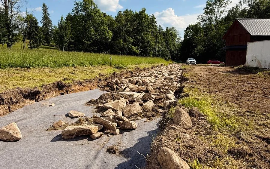 Kamenné podloží a geotextilie nové příjezdové cesty k roubenkám